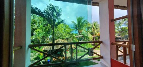 a window view of a resort with palm trees at Pousada Terra Mar Way in Barra Grande