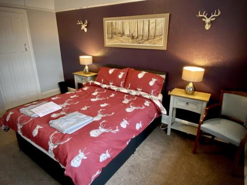 a bedroom with a red bed and a chair at The wrey arms inn in Barnstaple