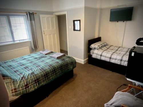 1 dormitorio con 2 camas y TV. en The wrey arms inn en Barnstaple