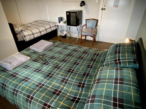 a bedroom with a bed with a plaid blanket at The wrey arms inn in Barnstaple