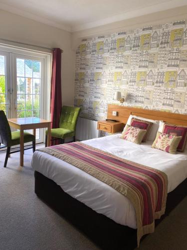 a hotel room with a bed and a table and a window at Alton House Hotel in Alton