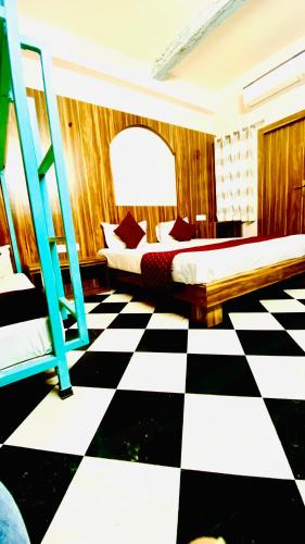 a bedroom with two beds and a checkered floor at The Uddhav Elite in Udaipur