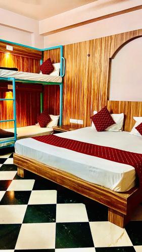two beds in a room with a checkered floor at The Uddhav Elite in Udaipur