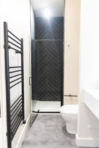 a bathroom with a toilet and a glass shower at School Lane Hotel in Liverpool ONE in Liverpool