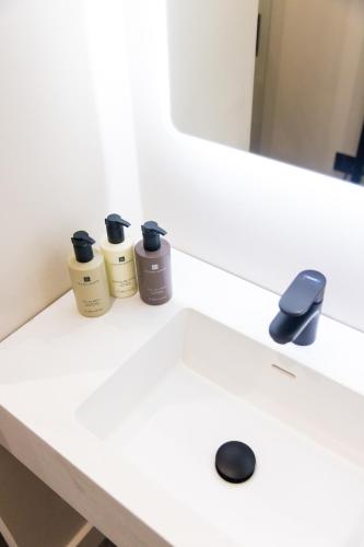 a white bathroom sink with two bottles on it at School Lane Hotel in Liverpool ONE in Liverpool