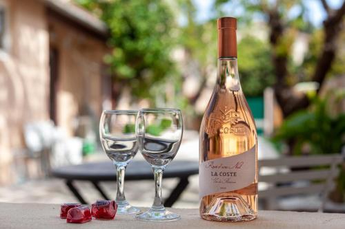 une bouteille de vin et deux verres à vin sur une table dans l'établissement Love Room avec Balnéo, à Toulon