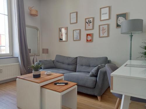 uma sala de estar com um sofá e uma mesa em Nancy Ville em Nancy