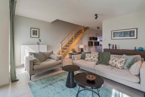 a living room with two couches and a staircase at Smeysea - Stylish apartment in Sint-Idesbald in Sint-Idesbald