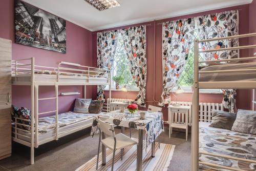 a bedroom with two bunk beds and a table and chairs at Kamienica in Płock