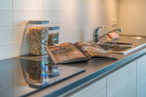 a counter with two books and a vase of seeds at Smeysea - Stylish apartment in Sint-Idesbald in Sint-Idesbald
