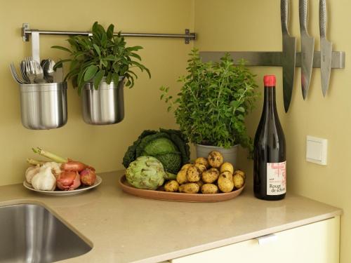 a bottle of wine and a plate of vegetables on a counter at Apēron Apartment Hotel in Copenhagen