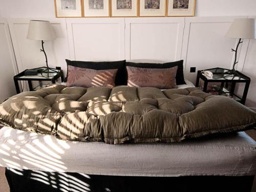 a large bed in a bedroom with two tables at Monachyle Mhor Hotel in Lochearnhead