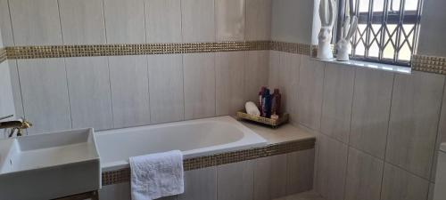 uma casa de banho branca com uma banheira e um lavatório em The Throne em Joanesburgo