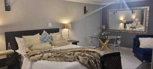 a bedroom with a large bed and a mirror at The Throne in Johannesburg