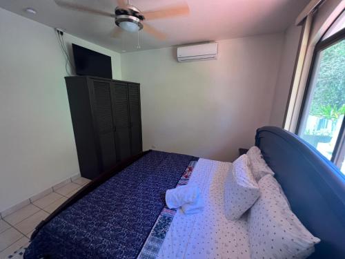1 dormitorio con 1 cama en una habitación con ventana en Casa Serena's Perfect Surfing Retreat, en Esterillos