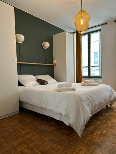 - une chambre avec un grand lit blanc et un mur vert dans l'établissement 102 - Terrasse de la Bastide, à Carcassonne