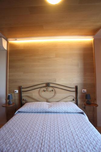 a large bed with a wooden headboard in a bedroom at B&b La Fontana Borbone in Lauria