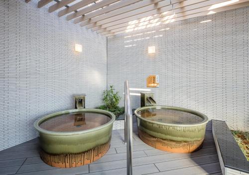two large tubs sitting in a bathroom with at APA Hotel Shinagawa Sengakuji Ekimae in Tokyo