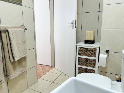 a bathroom with a sink and a toilet and a shower at Bali in Blouberg in Cape Town
