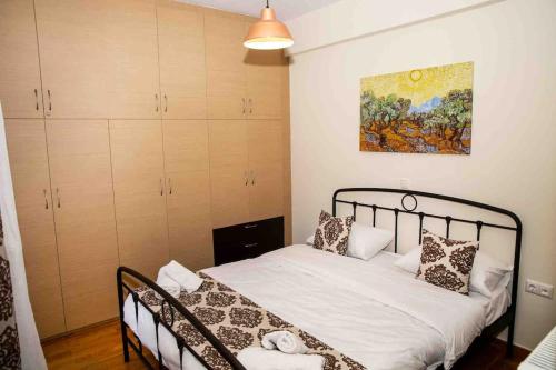 a bedroom with a bed and a painting on the wall at Lavrio Seaview 2bdr Apt 4 min dive from the sea in Lávrion