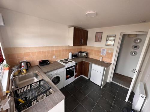 a small kitchen with a stove and a sink at Semi-detached chalet - Uddingston, Glasgow in Uddingston