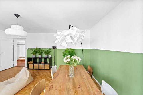 a dining room with a wooden table with a vase of flowers at Muenstergasse Zurich Old Town in Zürich