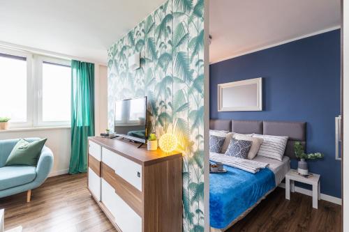1 dormitorio con cama y pared azul en SuperApart Etiudy Rewolucyjnej 9, en Varsovia