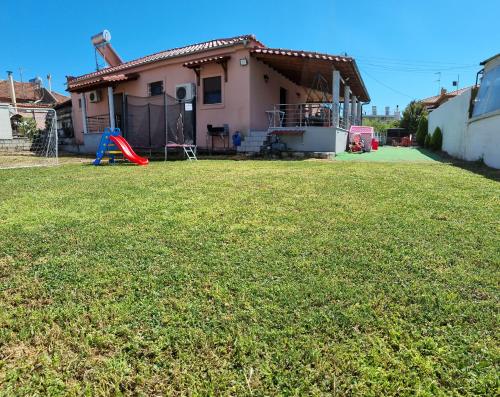 a house with a yard with a playground at Tom's House in Néa Karváli