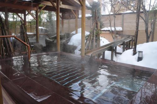 a swimming pool with snow on the ground at Yuzawa Grand Hotel in Yuzawa