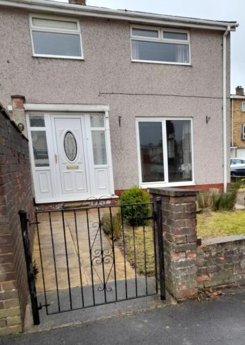 a house with a gate and a white door at Quiet 3 bed close to the A1 in Newton Aycliffe