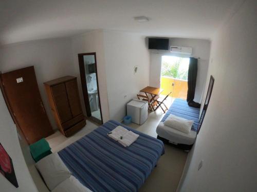 a small room with two beds and a mirror at Pousada Atlantic Sun in Bertioga