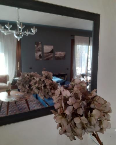 a mirror in a living room with a flower arrangement at Residenza Borgo San Rocco in SantʼAmbrogio di Valpolicella