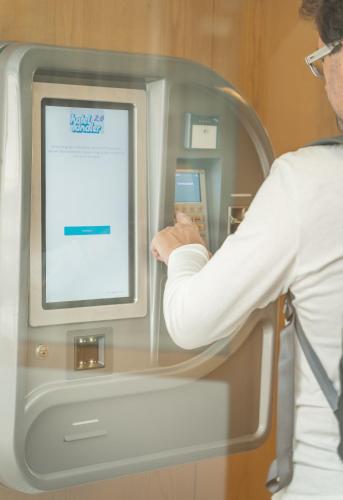 a man is looking at a computer screen at Hotel Kindler 2,0 Self-Check-In in Leoben