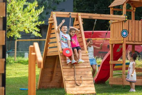 a group of children playing on a wooden playground at Villa Pino in Velingrad