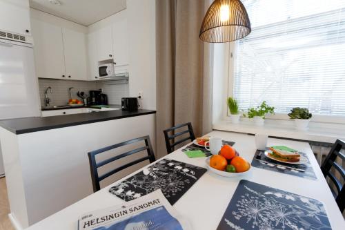 a kitchen with a table with a bowl of fruit on it at Forenom Serviced Apartments Helsinki Kruununhaka in Helsinki