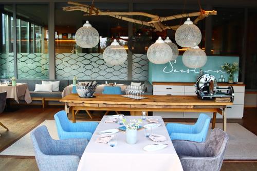 ein Esszimmer mit einem Tisch und blauen Stühlen in der Unterkunft LAGO hotel & restaurant am see in Ulm