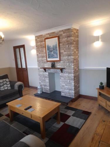 a living room with a brick fireplace and a coffee table at Quiet 3 bed close to the A1 in Newton Aycliffe