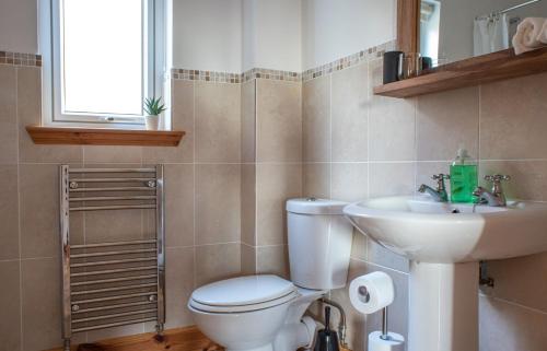 a bathroom with a toilet and a sink at Bay View Bungalow in Uig