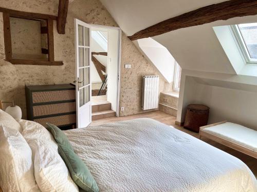 ein Schlafzimmer mit einem großen Bett im Dachgeschoss in der Unterkunft Le Relai de Boissée in Blois