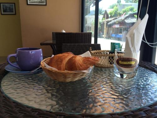 a table with a basket of bread and a glass of water at Harmony Bed & Bakery in Ko Lipe