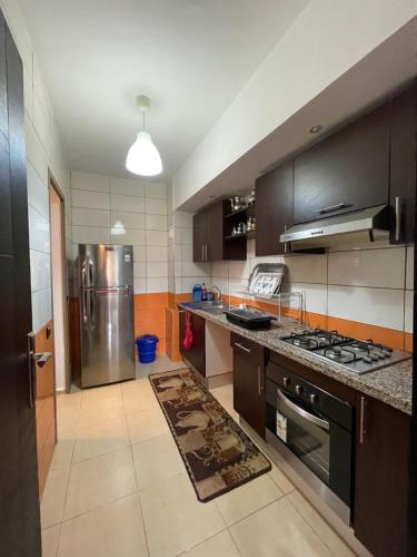 una cucina con piano cottura e frigorifero di Appartement en résidence privée a Marrakech