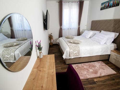 a bedroom with two beds and a mirror at Apartments Hera in Mošćenička Draga