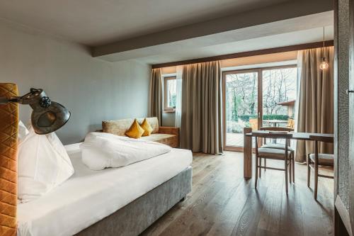 a bedroom with a bed and a table and a desk at Hosler in Merano