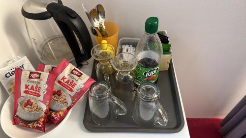ein Tablett mit Getränken und Gläsern auf dem Tisch in der Unterkunft Tantra klub "Chaty Steva Jobse" in Prag