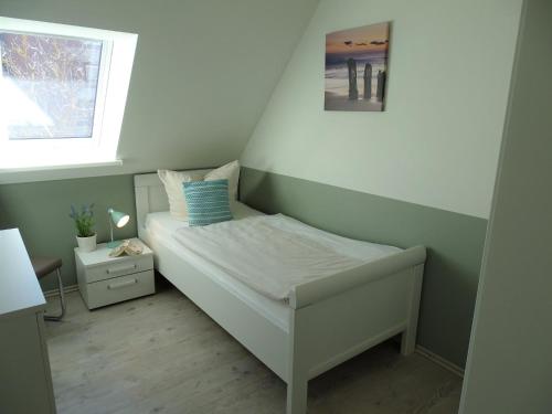 małe łóżko w pokoju z oknem w obiekcie Strand Quartiere Koje 9 w mieście Dahme