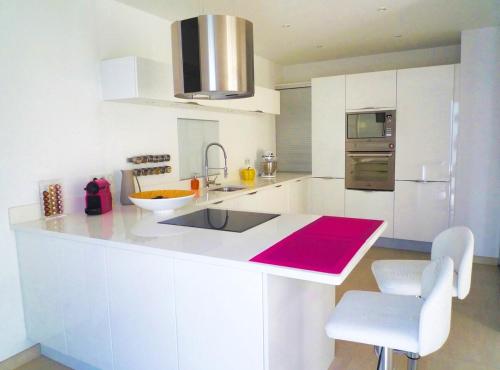 une cuisine blanche avec un évier et un comptoir dans l'établissement Beautiful and spacious apartment with a lovely garden, à Cannes