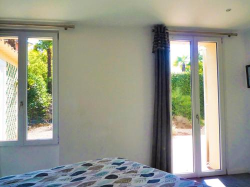 - une chambre avec un lit et deux portes coulissantes en verre dans l'établissement Beautiful and spacious apartment with a lovely garden, à Cannes