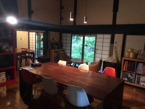 a dining room with a large wooden table and chairs at sabouしが in Matsumoto