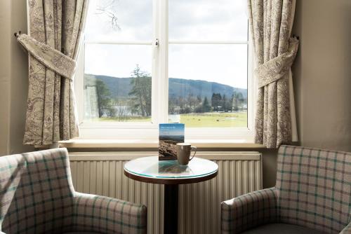 a room with two chairs and a table and a window at The Coniston Inn - The Inn Collection Group in Coniston