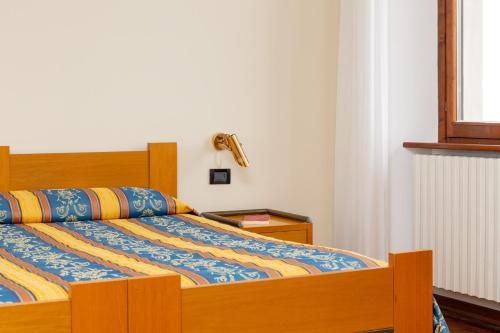 a bed with a colorful comforter in a bedroom at Albergo Sacro Monte Varese in Varese